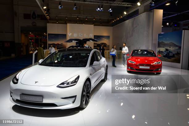 Tesla Model 3 compact sedan car in white with a Tesla Model S dual motor all electric sedan in red on display at Brussels Expo on JANUARY 09, 2020 in...