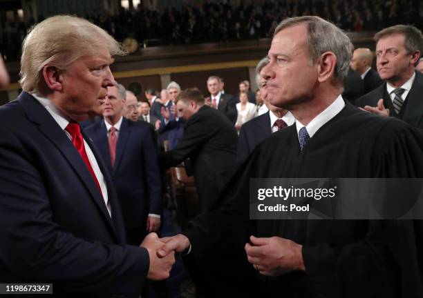 President Donald Trump shakes hands with Supreme Court Chief Justice John Roberts before the State of the Union address in the House chamber on...