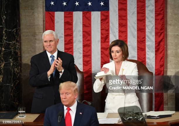 Vice President Mike Pence claps as Speaker of the US House of Representatives Nancy Pelosi appears to rip a copy of US President Donald Trump speech...
