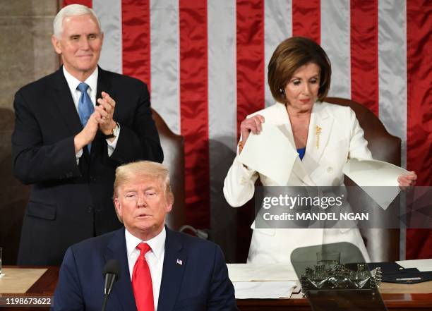 Vice President Mike Pence claps as Speaker of the US House of Representatives Nancy Pelosi appears to rip a copy of US President Donald Trumps speech...