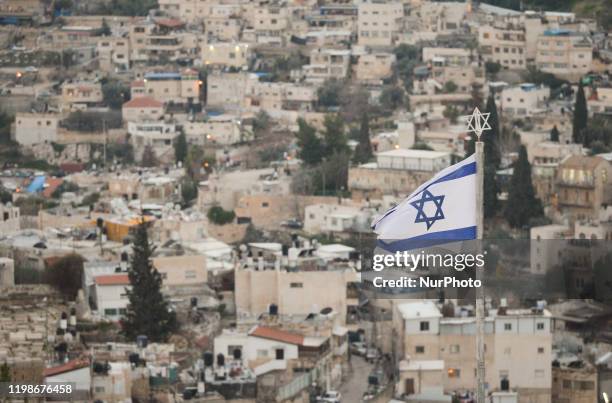 An Israeli national flag seen from Mount of Olives in Jerusalem. On Tuesday, February 4 in Jerusalem, Israel.Jerusalem's Jewish Cemetery. On Tuesday,...