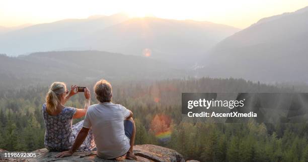 volwassen paar ontspan op bergrichel, kijk uit om te bekijken - canadese rocky mountains stockfoto's en -beelden