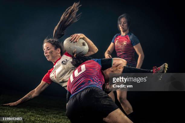 female rugby player getting tackled - rugby sport stock pictures, royalty-free photos & images