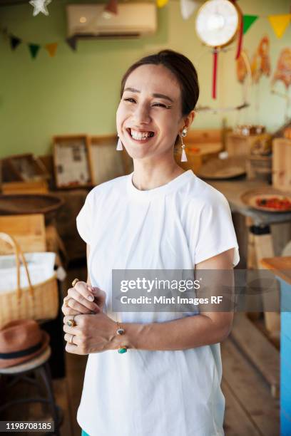 smiling japanese woman standing in a farm shop, looking at camera. - 女性　日本人　笑顔　30代 ストックフォトと画像