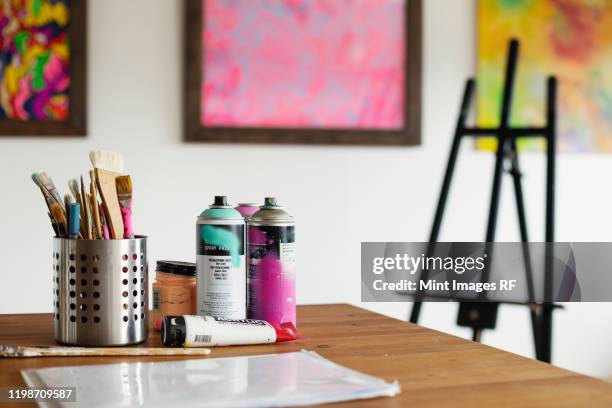 interior view or art gallery with studio space, easels and cans of spray paint on a table. - creative rf stockfoto's en -beelden