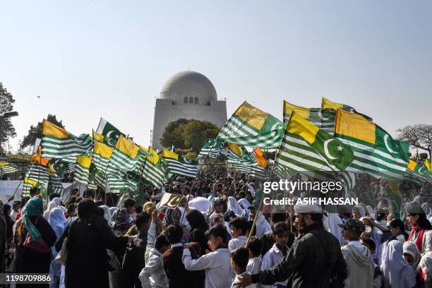 Protesters hold Kashmiri flags as they gather in front of the mausoleum of Pakistan's founder Muhammad Ali Jinnah during a demonstration to mark...