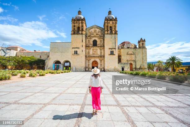 one woman walking towards the oaxaca monastery, mexico - oaxaca foto e immagini stock