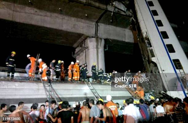 Chinese firefighters work to rescue survivors after a Chinese high-speed train derailed and two of its carriages fell off a bridge after a lightning...