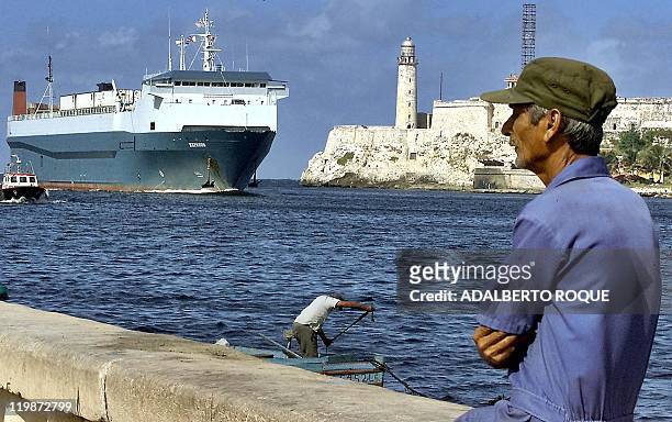Havana resident watches as the Express container ship docks 16 December with 20 containers of frozen chicken, worth about 300,000 USD, shipped from...