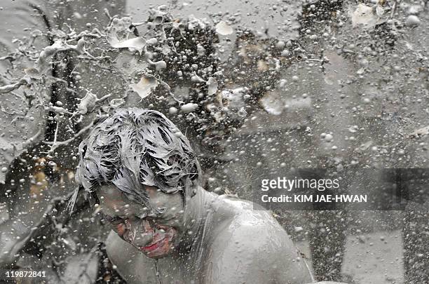 Tourist is covered with mud during the Boryeong Mud Festival at the Daecheon swimming beach in Boryeong, 190 kilometers southwest of Seoul on July...