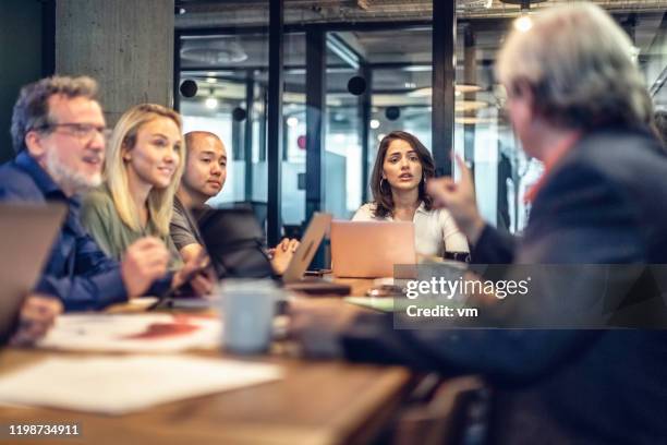 zakelijke discussies op een vergadertafel - multi generation family stockfoto's en -beelden