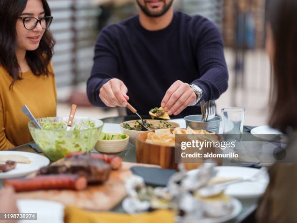 young latin people eating together - mexican food on table stock pictures, royalty-free photos & images
