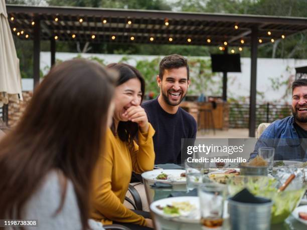 cheerful friends having gathering - jantar festivo imagens e fotografias de stock