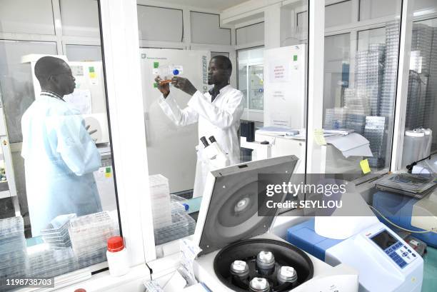 Scientific staff members works in a secure laboratory, researching the coronavirus, at the Pasteur Institute in Dakar on February 3, 2020. The...