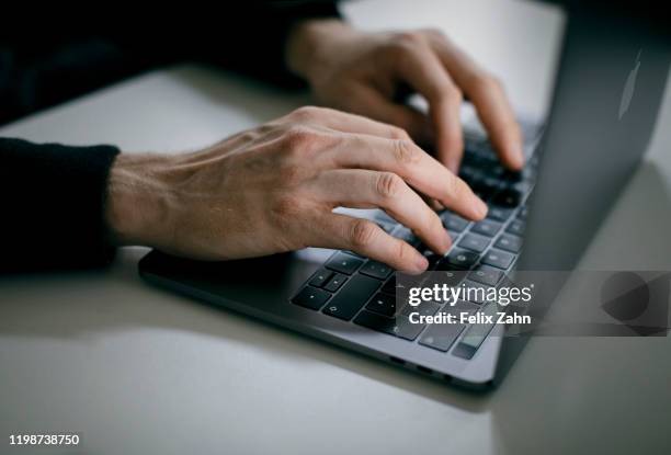 Symbol photo. A man is typing with his hands on a keyboard of a MacBook Pro on February 04, 2020 in Berlin, Germany.