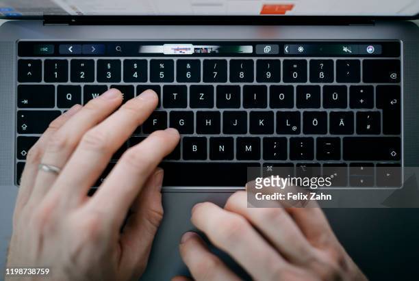 Symbol photo. A man is typing with his hands on a keyboard of a MacBook Pro on February 04, 2020 in Berlin, Germany.