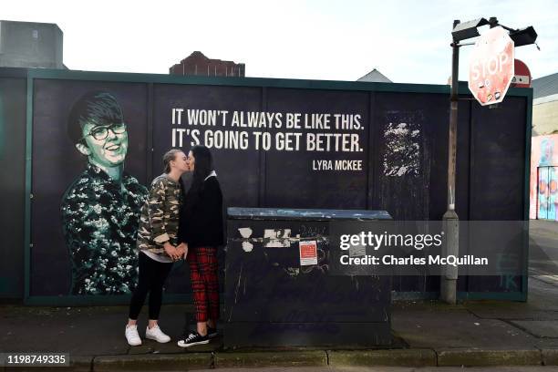 Robyn Peoples and Sharni Edwards, Northern Ireland's first same-sex couple to be legally married, kiss as they pose in front of the Lyra McKee mural...