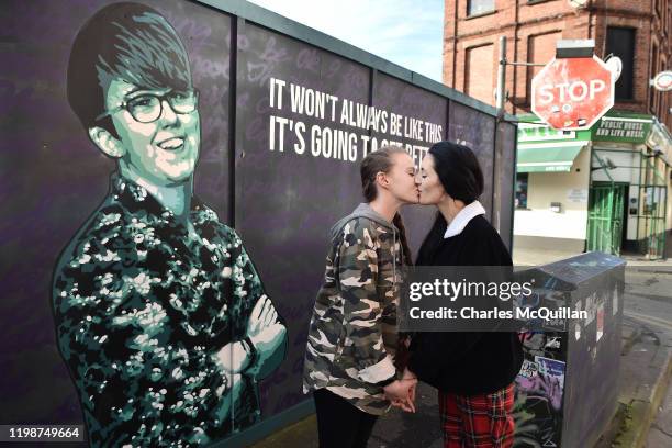 Robyn Peoples and Sharni Edwards, Northern Ireland's first same-sex couple to be legally married, kiss as they pose in front of the Lyra McKee mural...