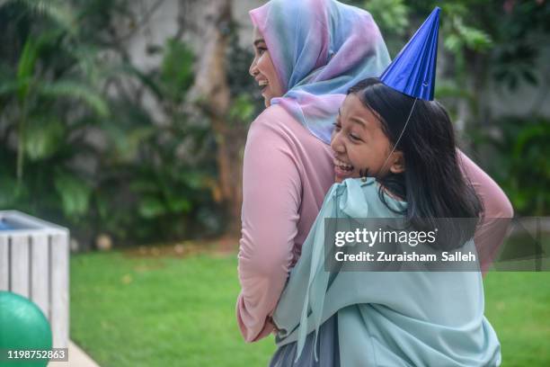 asian muslim family celebrating birthday in garden - birthday girl stock pictures, royalty-free photos & images