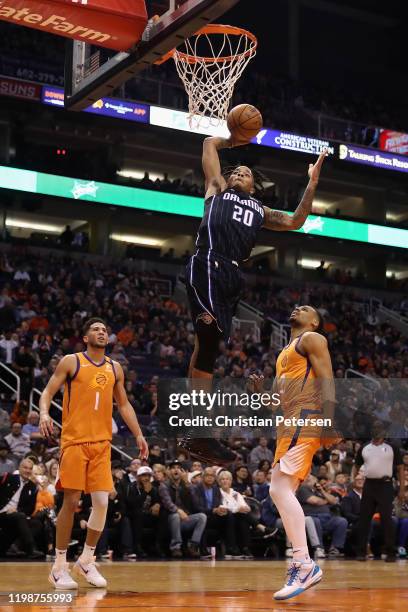 Markelle Fultz of the Orlando Magic goes up for a slam dunk over Devin Booker and Elie Okobo of the Phoenix Suns during the first half of the NBA...