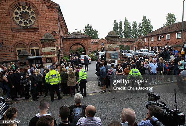 Media and members of the public gather outside the gates as family and friends arrive for the cremation of Amy Winehouse at Golders Green Crematorium...