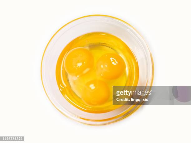 abstract pattern formed by three opened eggs in glass bowl - dotter stock-fotos und bilder