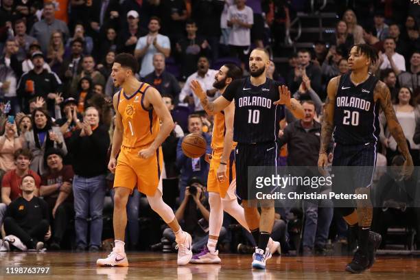 Devin Booker of the Phoenix Suns celebrates ahead of Ricky Rubio and Evan Fournier and Markelle Fultz of the Orlando Magic during the second half of...