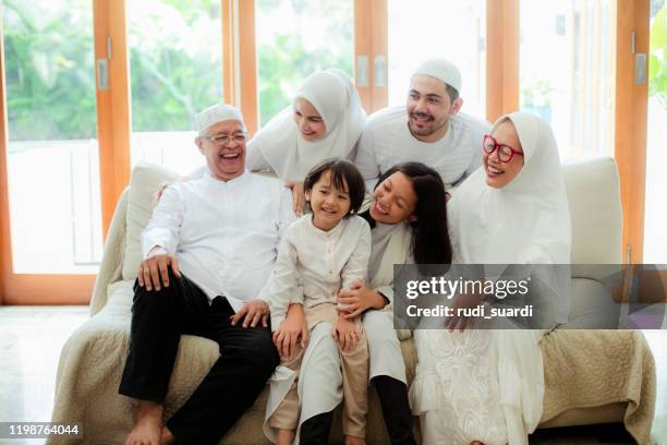 familie aufgeghattet und nimmt elternsegen während eidul-fitr - indonesischer archipel stock-fotos und bilder