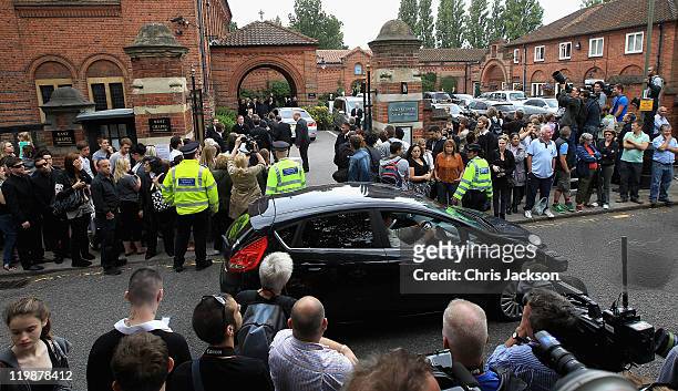 Media and members of the public gather outside the gates as family and friends arrive for the cremation of Amy Winehouse at Golders Green Crematorium...