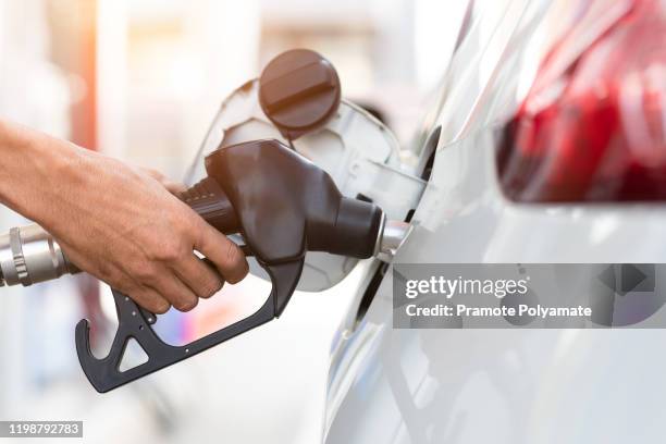 hand refilling the car with fuel, close-up, pumping equipment gas at gas station. - gas station ストックフォトと画像