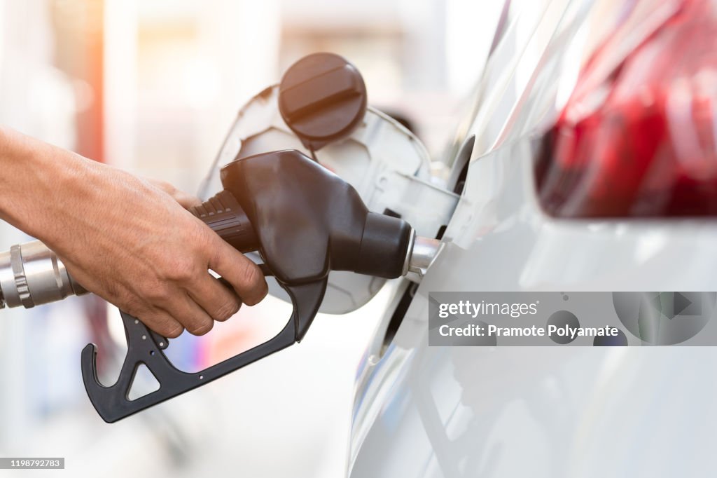 Hand refilling the car with fuel, close-up, Pumping equipment gas at gas station.
