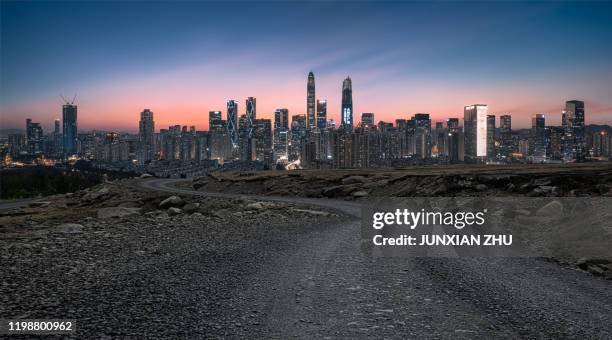 dirt road pavement and shenzhen city buildings skyline - skyline dusk stock pictures, royalty-free photos & images