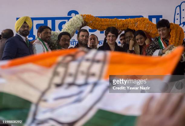 Supporter of Indian National Congress, garland Rahul Gandhi, leader of Indian National Congress, speaks to his sister Priyanka Gandhi, general...