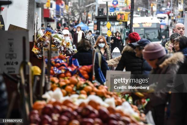 Pedestrian wearing a face mask walks along a street in the Flushing neighborhood in the Queens Borough of New York, U.S., on Wednesday, Feb. 5, 2020....