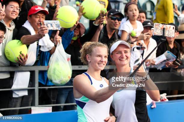 Katerina Siniakova of the Czech Republic and Barbora Krejcikova of the Czech Republic take selfies with fans after winning the doubles final match...