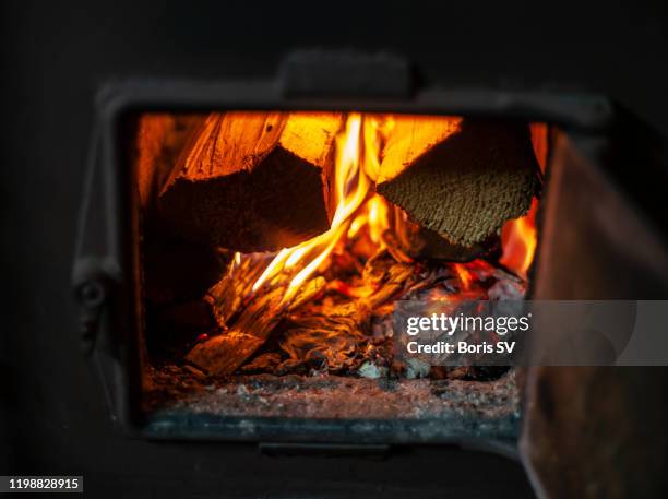 wood burning in cast iron stove - wood burning stove stock-fotos und bilder