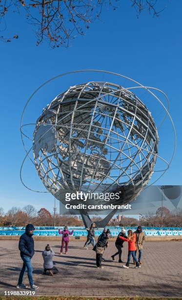 toeristen die foto's maken voor de giant globe - flushing queens stockfoto's en -beelden