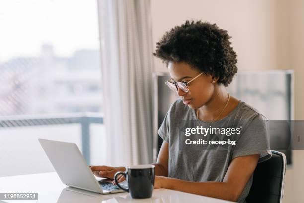 jonge zwarte mooie vrouw met laptop thuis - beautiful asian student stockfoto's en -beelden