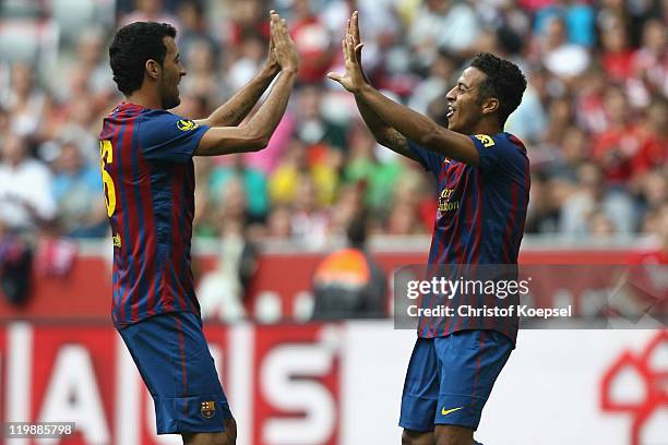 Thiago Alcantara of Barcelona celebrates the first goal with Sergio Busquets during the Audi Cup match between FC Barcelona and International de...