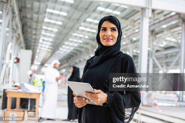 abu dhabi construction professional using digital tablet - emarati woman stock pictures, royalty-free photos & images