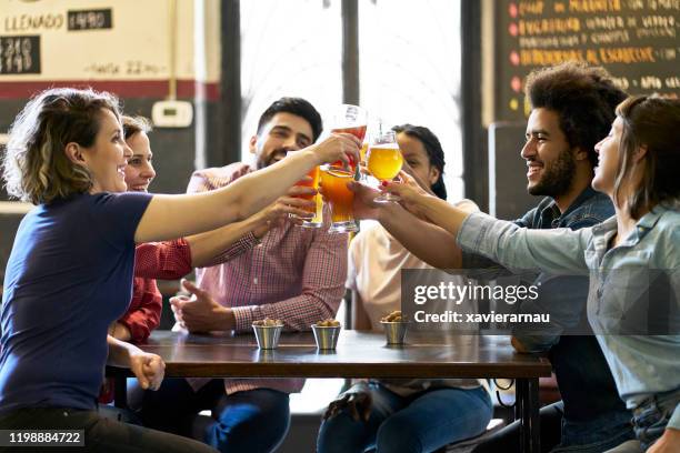 vrienden toasten met ambachtelijke bieren in de bar van buenos aires - artisanal food and drink stockfoto's en -beelden