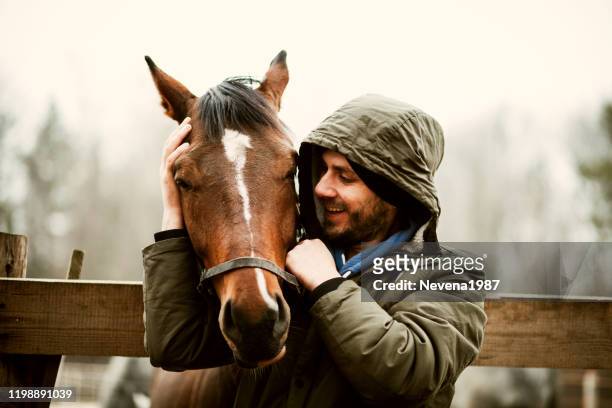 giovanotto che bacia beautiful horse. - cavallo equino foto e immagini stock