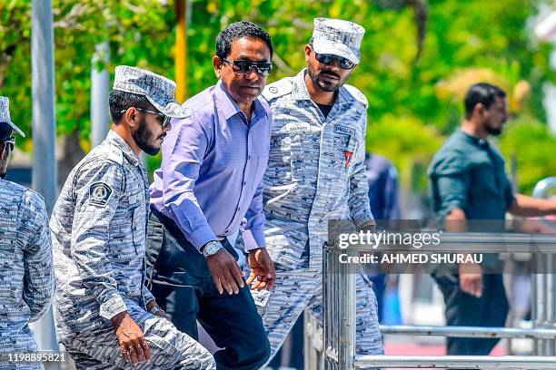 Former Maldives' president Abdulla Yameen looks on as he is escorted to board a speedboat of Correctional Service heading back to prison, after the...