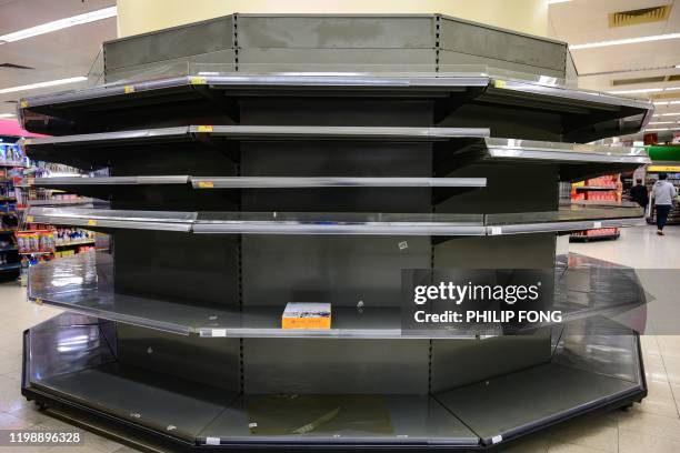 Ream of A4 paper is seen placed on bare supermarket shelving, usually stocked with toilet paper and kitchen rolls, in Hong Kong on February 6, 2020....