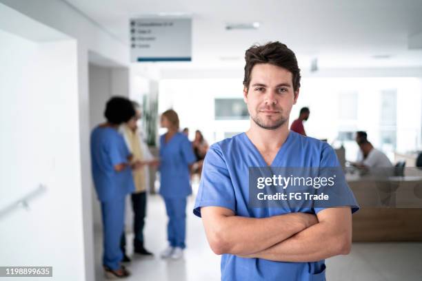 portrait of male nurse at hospital - doctors arms crossed stock pictures, royalty-free photos & images