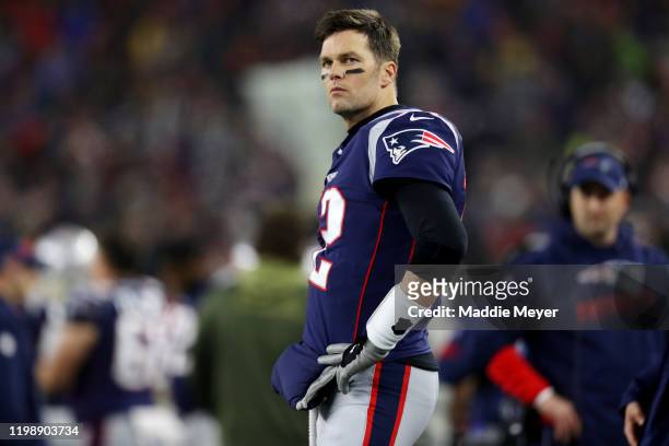 Tom Brady of the New England Patriots looks on from the sideline during the the AFC Wild Card Playoff game against the Tennessee Titans at Gillette...