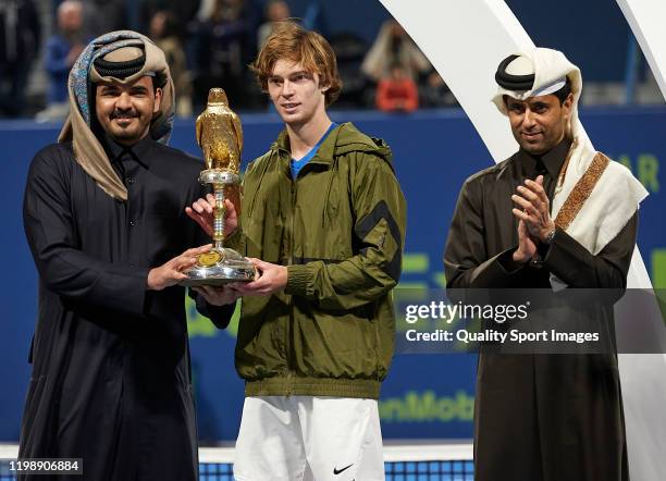 Andrey Rublev of Russia is handed the championship trophy by Sheikh Joaan Bin Hamad Al Thani and Nasser Al-Khelaifi, president of Qatar Tennis...