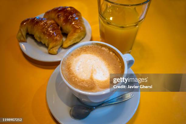 taza de café con leche, medialunas de manteca y vaso de jugo de naranja exprimido - taza cafe stock pictures, royalty-free photos & images