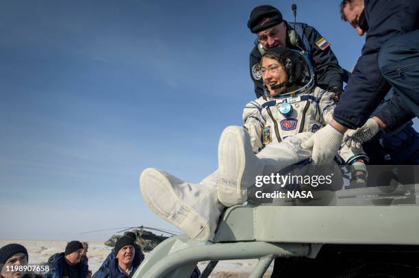 In this handout image supplied by NASA, NASA astronaut Christina Koch is helped out of the Soyuz MS-13 spacecraft just minutes after she, Roscosmos...