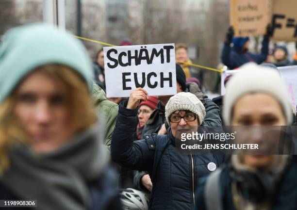 One day after the election of Thuringia's State Premier, a young woman holds a placard reading "Shame on you" during a protest in front of the State...